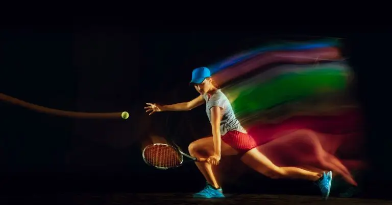 One caucasian woman playing tennis isolated on black background in mixed and stobe light. Fit young female player in motion or action during sport game. Concept of movement, sport, healthy lifestyle.